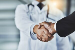 Doktor schüttelt Patienten die Hand